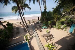 an overhead view of a beach with a table and benches at Hikks Villa in Hikkaduwa