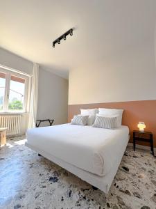 a bedroom with a large white bed and a window at Borgo Design Apartment by the sea in Civitavecchia
