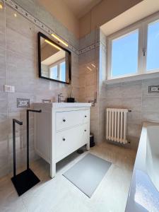un bagno con un lavandino bianco e uno specchio di Borgo Design Apartment by the sea a Civitavecchia