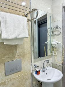 een badkamer met een wastafel en een spiegel bij The Reina Hotel in Istanbul