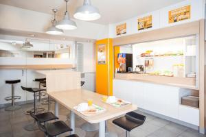 a dining room with a table and chairs and a restaurant at hotelF1 Besancon Ouest Micropolis in Besançon