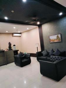 a lobby with two black couches in a room at Room for rent - SMR in Cebu City