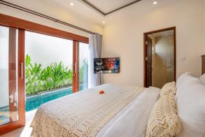 a bedroom with a large bed and a pool at Ellavie Villa Nusa Dua in Nusa Dua +91 photos
