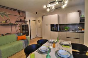 a living room with a table and a green couch at Lussuoso Appartamento vista lago con spiaggia privata in Bardolino +14 photos
