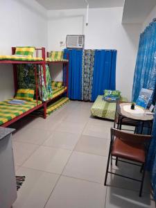 a room with two bunk beds and a table at Room for rent - SMR in Cebu City