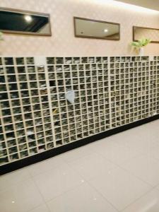 a bathroom with a tile wall with a mirror at Room for rent - SMR in Cebu City