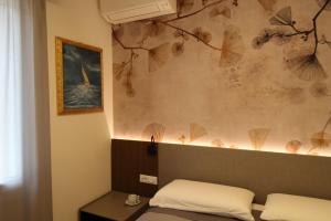 a room with a bed and a painting on the wall at Lussuoso Appartamento vista lago con spiaggia privata in Bardolino