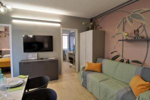 a living room with a green couch and a table at Lussuoso Appartamento vista lago con spiaggia privata in Bardolino