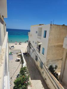 a building on the beach with the ocean in the background at Résidence BAYA in Chott Meriem