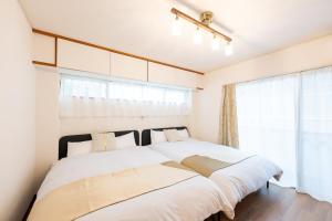 due letti in una camera da letto con finestra di Vacation Rental -Nagumo301- a Tokyo