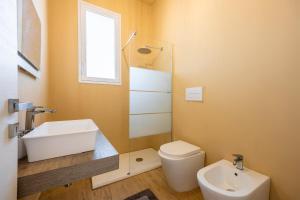 Un baño con lavabo, inodoro y ventana. en Villa Francesca - Beach and Airport, en Carini 20 fotos más