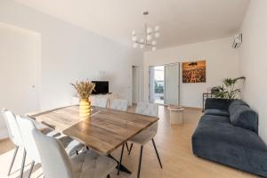 Una sala de estar con una mesa de madera y un sofá. en Villa Francesca - Beach and Airport, en Carini
