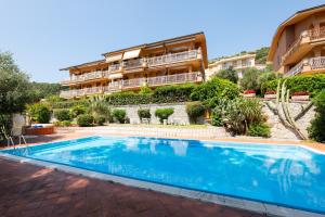 ボルディゲーラにあるGuestHost - Bordighera Terrace APT with Parking & Shared Poolの建物の前のプール