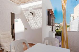 una sala da pranzo bianca con tavolo e sedie di Sea Nest a Balestrate