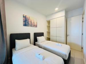 zwei Betten nebeneinander in einem Zimmer in der Unterkunft The Shore Premium Melaka By I Housing in Malakka
