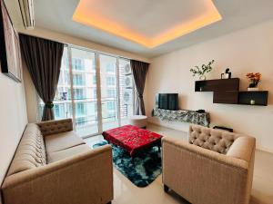 ein Wohnzimmer mit zwei Sofas und einem Tisch in der Unterkunft The Shore Premium Melaka By I Housing in Malakka