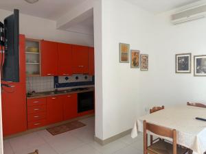 a kitchen with red cabinets and a table with a tableablish at Torre Lapillo in Torre Lapillo