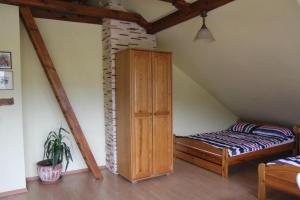 a bedroom with a bed and a cabinet in a attic at Gospodarstwo Agroturystyczne Natalia Bębnista - Stajnia Morgan in Balczewo +14 photos