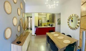 a dining room with a table and a kitchen at Palm Villa GuestHouse in Jwaneng