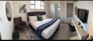 a bedroom with a large bed and a television at Palm Villa GuestHouse in Jwaneng