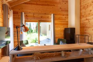 a living room with wooden walls and a large window at Ferienhaus Blockhouse 8 mit Sauna, Terrasse und Grill in Braunlage +25 photos