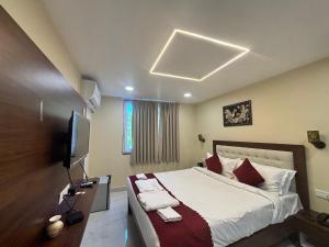 a bedroom with a large bed and a television at Hotel OP Palace in Colva