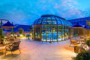 a glass house with tables and chairs in a patio at Kimpton BEM Budapest by IHG in Budapest