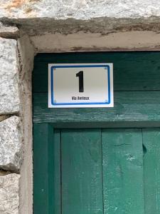 a sign above a green door with the number one at Cabin Valle Cervo 