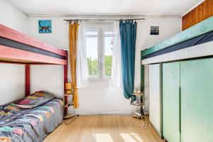 una camera da letto con due letti a castello e una finestra di Maison de l’océan - Hourtin, Médoc a Hourtin