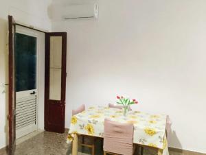a white table with a vase of flowers on it at La casa di Anna Maria in Nardò