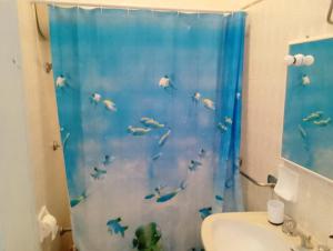 a bathroom with a shower curtain with a fish at La casa di Anna Maria in Nardò
