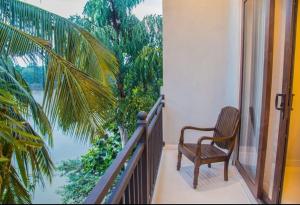 a chair on a balcony with a view of the water at Hotel Malika Inn  +2 photos