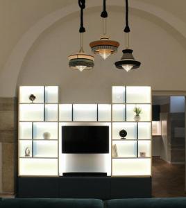 een woonkamer met een televisie en witte planken bij Loft Green Trani in Trani