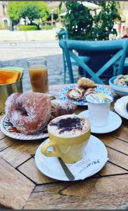 una mesa con platos de donas y una taza de café en Rooms Plaza, en Marina di Camerota