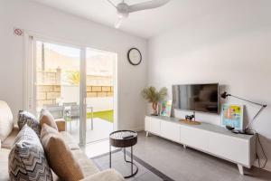 a living room with a couch and a tv at Sunset Gabriela in Candelaria