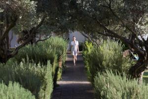 Una donna che cammina lungo un sentiero attraverso un giardino di Almyra a Paphos
