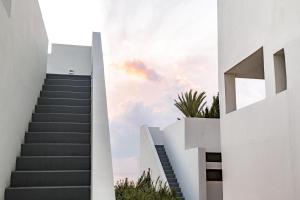 una scala che porta a un edificio bianco con un cielo di Almyra a Paphos