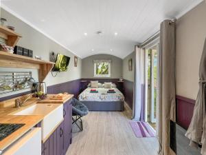 una cocina y un dormitorio con una cama en una habitación en Valley View Retreats- West Down Farm Estate, en North Molton