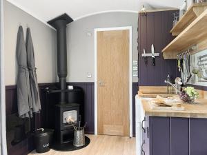 una cocina con estufa de leña en una habitación en Valley View Retreats- West Down Farm Estate, en North Molton