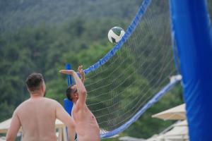 a couple of men playing a game of volleyball at Makryammos in Limenas