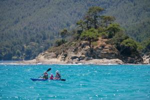 a group of people in a kayak in the water at Makryammos in Limenas