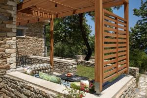 a wooden pergola with a bench in a yard at Makryammos in Limenas