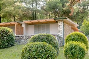 a house with bushes in front of it at Makryammos in Limenas