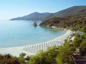 a beach with a bunch of chairs and the water at Makryammos in Limenas