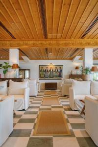 a living room with white couches and a checkered floor at Makryammos in Limenas