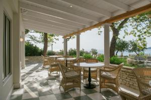 a patio with tables and chairs and a view of the ocean at Makryammos in Limenas