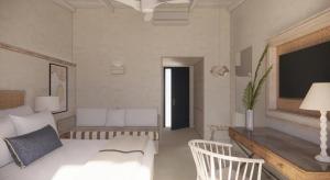 a living room with a white bed and a television at Makryammos in Limenas