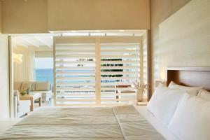 a bedroom with a bed with a view of the ocean at Makryammos in Limenas