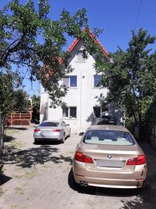 two cars parked in front of a house at Rent a room Bruno in Făgăraş