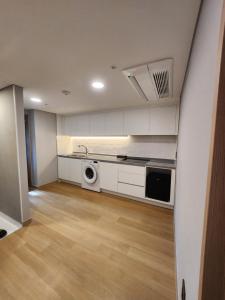 a kitchen with white cabinets and a washer and dryer at Seoul DDJ STAY 대동장 in Seoul +34 photos